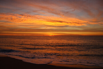 Fototapeta na wymiar Precioso amanecer en el mar con tonos anaranjados