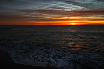 Fototapeta na wymiar Amanecer en el mar, el sol sale por el horizonte