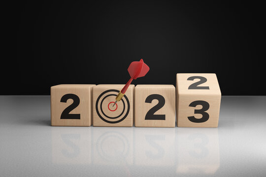 Wooden blocks are turning from 2022 to 2023 with a dart on the bullseye. Illustration of the concept of anniversary and plans for the new year