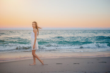 Fototapeta na wymiar Adorable happy little girl on the beach at sunset