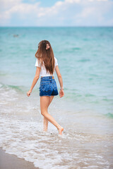 Fototapeta na wymiar Back. view of happy girl running on the beach