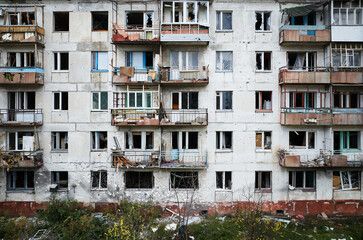 An apartment building in a war zone. Damage to a house as a result of artillery strikes. War in residential areas, broken windows and burned apartments. Armed Conflict in Ukraine