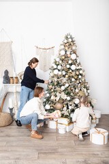 Senior woman ,her pretty daughter and cute granddaughter decorating Christmas tree together