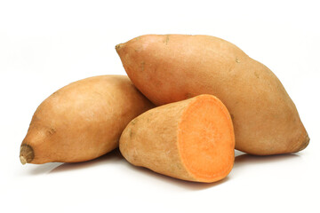 Two whole and half sliced batatas sweet potatoes isolated on white background