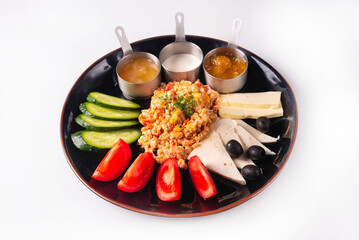 fried mixed eggs with fresh tomatoes and cucumbers, cheese with olives with three sauces. on a white background