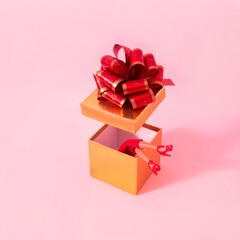 An open golden gift box with women legs in red trousers and shoes. The box lid with a big red knot hanging above. Pink background. Surreal minimal concept for season greetings card or banner. 