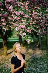 Blonde young woman at blossom garden.