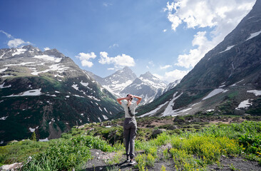 Fototapeta na wymiar Travel by Swiss Alps. Young woman enjoying the mountains view.
