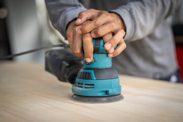 Sander machine, woodworking putty back polishing machine Hand sander for smoothing wood surfaces before painting. The carpenter uses both hands to control the tool while in use