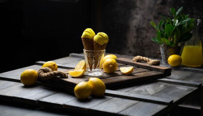fresh lemon citrus sorbet or ice cream with chopped fresh fruit on the wooden table on the background fresh lemon juice and vase with flowers in a fume. still life ice cream, juice, wood, fume
