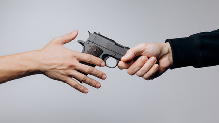 Attack and defense. Close up of male hand giving a pistol.