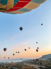 Fototapeta premium Hot air balloon flying over rocky landscapes in Cappadocia with beautiful sky on background