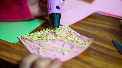 a girl draws with a 3D pen, education and creativity