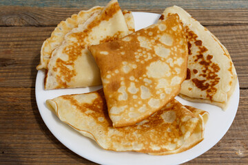 Delicious pancakes on an aged wooden table. National Russian pancakes.
