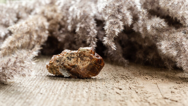 Raw andradite rock mineral sample on wood