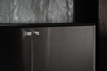 Steel handle on modern door of kitchen cupboard