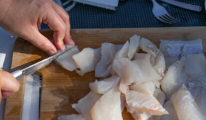 Fototapeta na wymiar person cutting fish on a wooden board