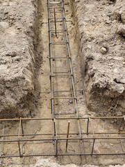 Steel reinforcement of foundations for a newly built house. The steel prets lie in the ground