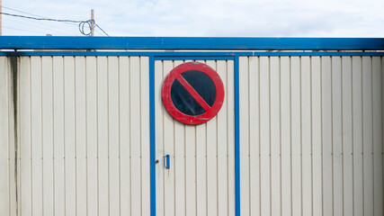 Señal de prohibido en pared de contenedor blanco de metal corrugado
