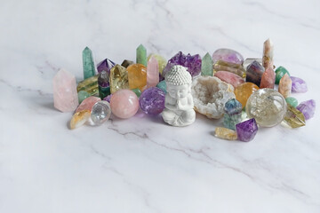 quartz minerals and Buddha statue on light marble background. gemstones crystals for healing...