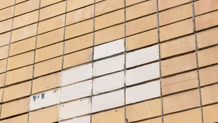 Baldosa blanca en pared de baldosas amarillas en fachada de edificio