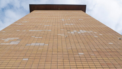 Baldosa blanca en pared de baldosas amarillas en fachada de edificio