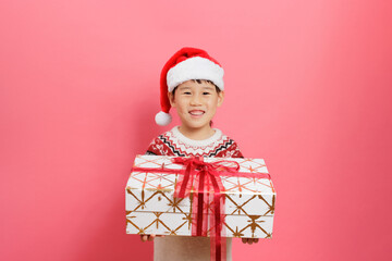 Merry Christmas! Young girl celebrating Christmas against pink background