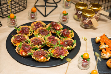 thin pastry tartlets with caramelized onions, roasted mushrooms, cherry tomatoes, and sprinkled with chopped arugula