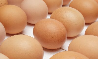 fresh chicken eggs laid out in rows on a white wooden table. selective focus. close up