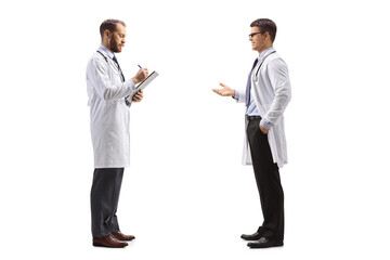 Doctor talking to a colleague standing and writing a document