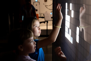 Two elementary school age children, girls interacting with a touchscreen together, kids and modern...