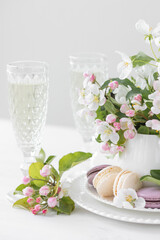 Beautiful composition with delicious French macarons and spring flowers in a white cup. Sweet dessert, early spring white and pink flowers, wedding decor, bride morning