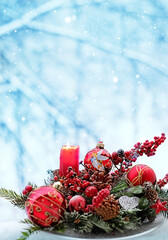 Christmas holiday. Red ball with angel image, candle, 
beautiful decorative composition, natural snowy winter background. symbol of Advent, hope, religion. winter festive season concept