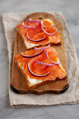Homemade Smoked Salmon Toast on a rustic wooden board, side view.