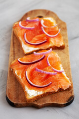 Homemade Smoked Salmon Toast on a rustic wooden board, low angle view.