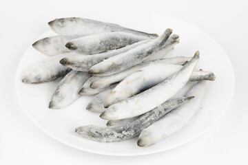 Whole frozen wild sea herring isolated on white background.