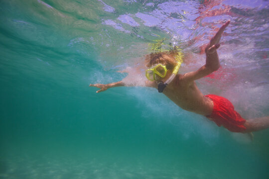 Side portrait underwater photo of a boy snorkeling in ocean