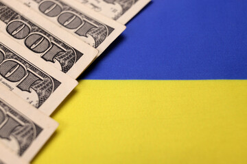 Ukrainian flag and American money dollars. The concept of lend lease, war in Ukraine, financial international donations, aid, support for countries