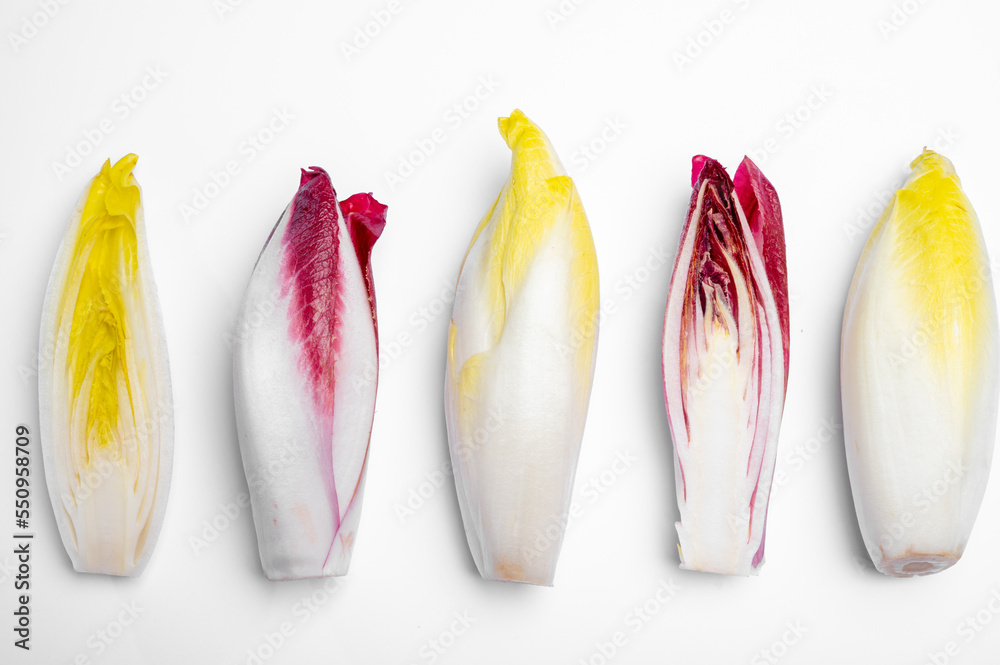 Wall mural fresh organic belgian endivi or green and red chicory lettuce close up isolated on white background