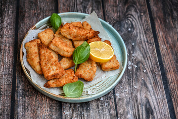   Allasca Pollock Fish  Bites in a crispy Tempura  Batter.Fish and chips .Close up of   crispy breaded  deep fried fish fingers with breadcrumbs s erved with remoulade sauce and  lemon
