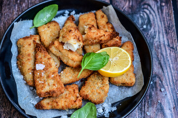   Allasca Pollock Fish  Bites in a crispy Tempura  Batter.Fish and chips .Close up of   crispy breaded  deep fried fish fingers with breadcrumbs s erved with remoulade sauce and  lemon