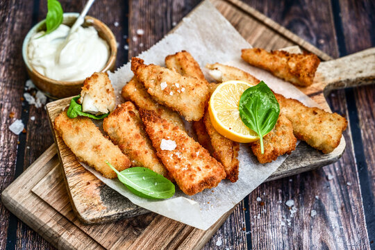   Allasca Pollock Fish  Bites in a crispy Tempura  Batter.Fish and chips .Close up of   crispy breaded  deep fried fish fingers with breadcrumbs s erved with remoulade sauce and  lemon