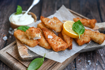   Allasca Pollock Fish  Bites in a crispy Tempura  Batter.Fish and chips .Close up of   crispy breaded  deep fried fish fingers with breadcrumbs s erved with remoulade sauce and  lemon