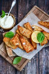   Allasca Pollock Fish  Bites in a crispy Tempura  Batter.Fish and chips .Close up of   crispy breaded  deep fried fish fingers with breadcrumbs s erved with remoulade sauce and  lemon