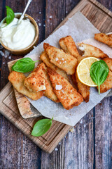   Allasca Pollock Fish  Bites in a crispy Tempura  Batter.Fish and chips .Close up of   crispy breaded  deep fried fish fingers with breadcrumbs s erved with remoulade sauce and  lemon