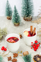 Obraz na płótnie Canvas Mulled wine with spices and traditional Christmas decor. Hot beverage, festive stone background