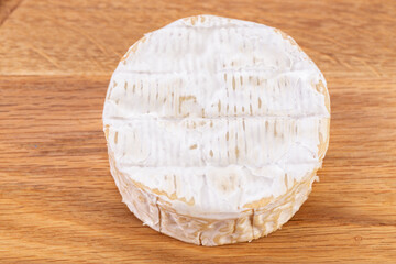 Brie type of cheese. Camembert cheese on a wooden table. Fresh Brie cheese. French cheese.