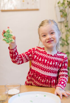 Smiling Little Girl Showing Off The Christmas Cookie She Just Decorated