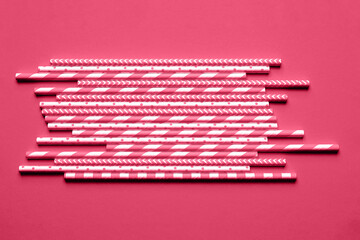 Pink paper straws on bright magenta background.