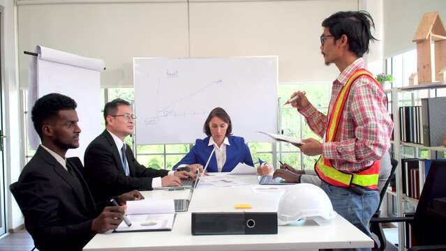 Asian architect worker man report explain with multiethnic business people meeting together on table with white board at office. Working man discussion project on table with manager business team.